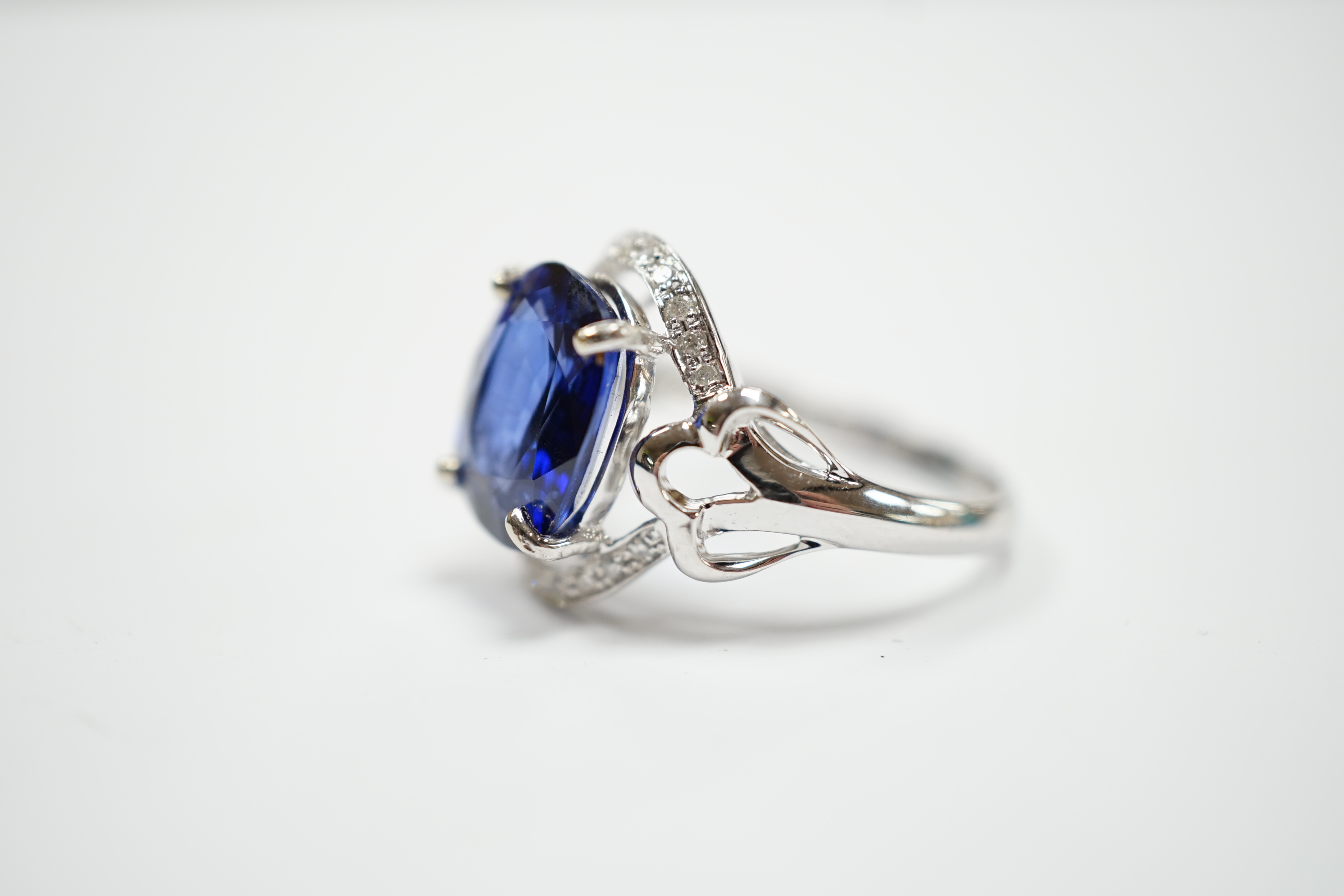 A modern 10k white metal, sapphire and diamond chip set oval cluster set dress ring, size M, gross weight 3.7 grams.